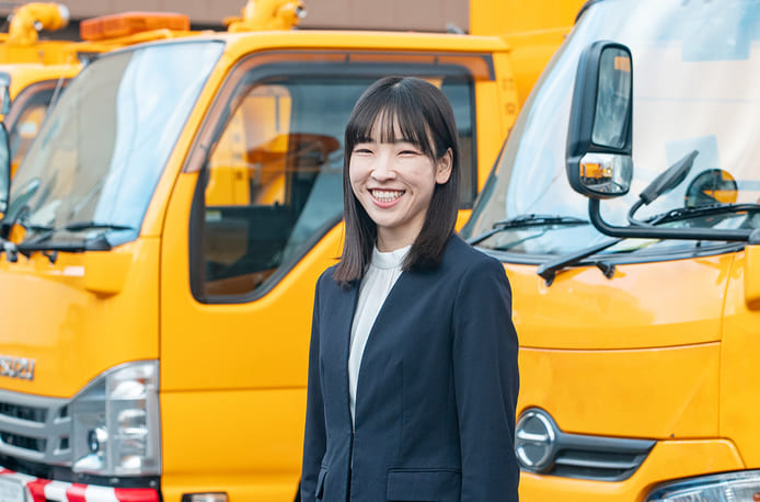 産業廃棄物の収集・処分・再資源化をコーディネイトする京葉興業で働く社員　作業部田澤が笑顔で作業車の前で立っている写真
